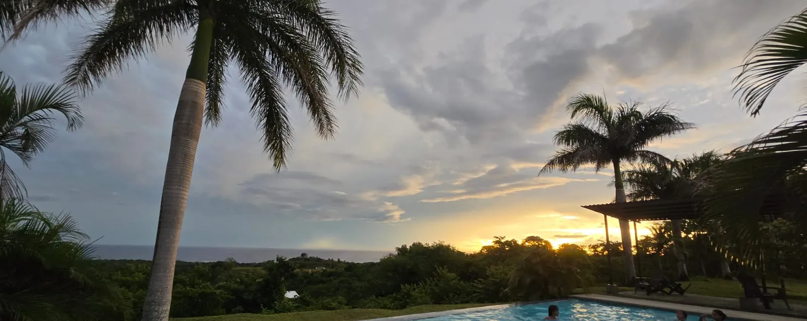 La vista desde lo alto del estate: la segunda piscina, la selva y el Pacífico al atardecer