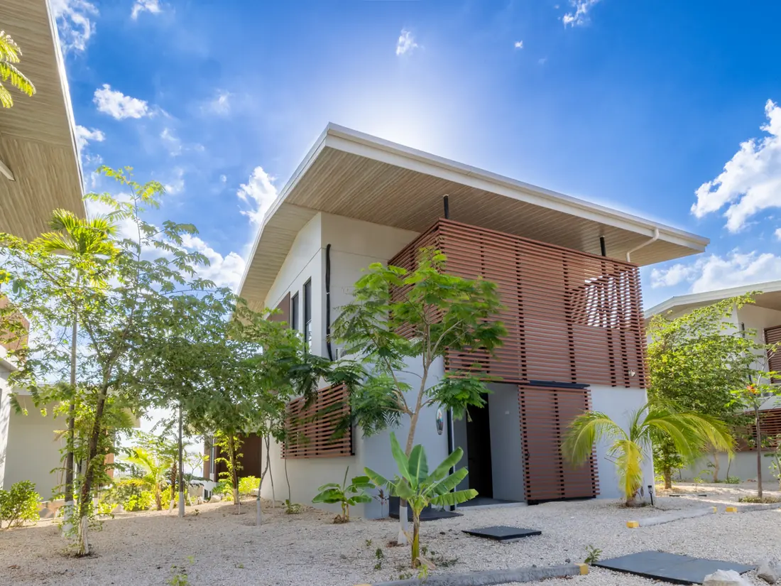 Villas privadas del estate con celosías de madera bajo cielo despejado